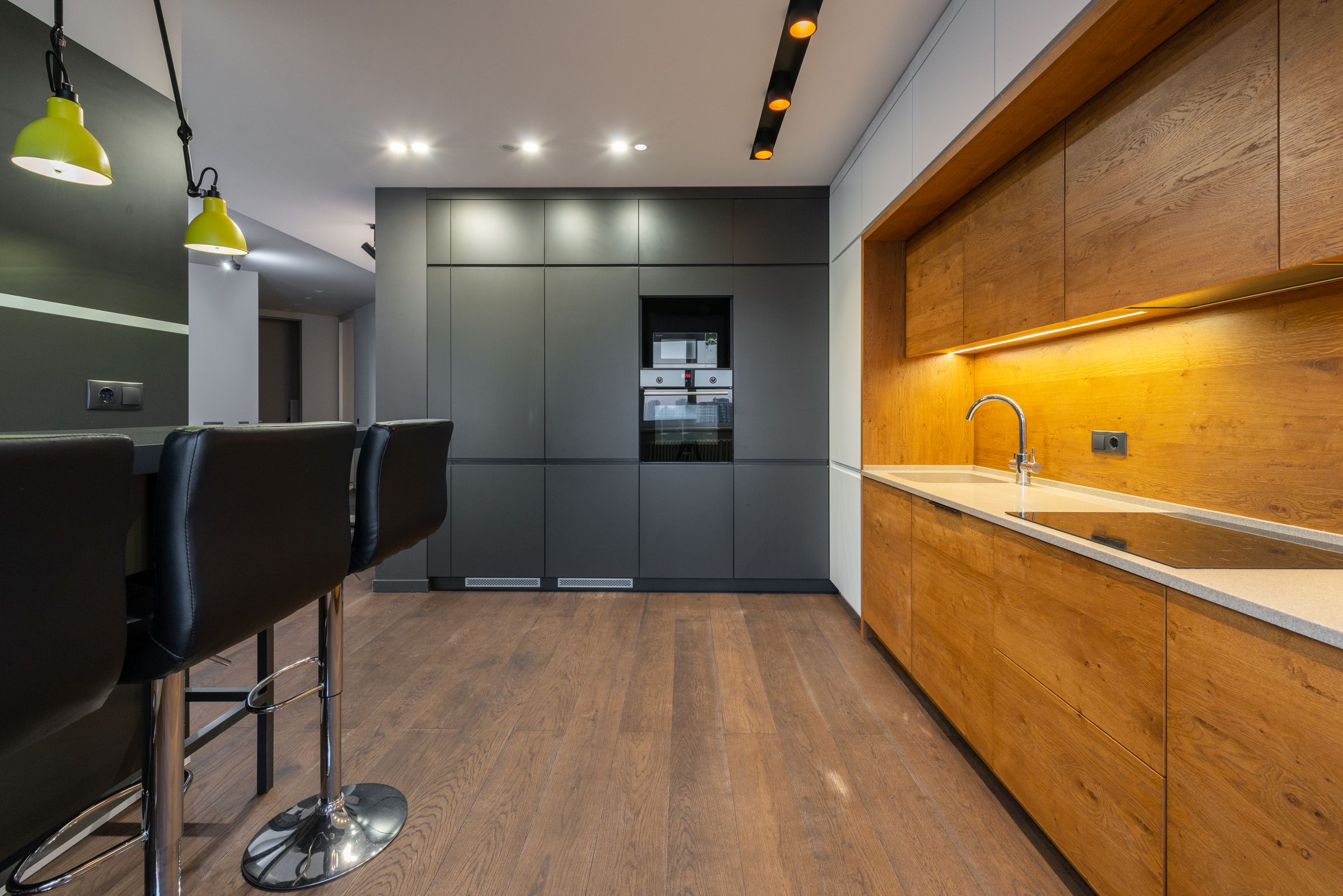 A finished kitchen in warm oak and grey with morning light across the island