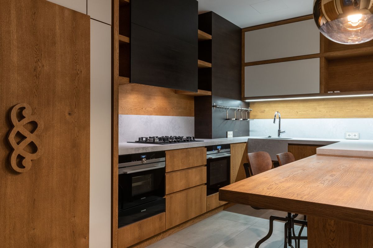 Oak and black kitchen cabinetry with a copper pendant light